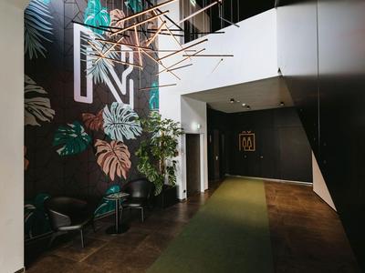 Moderner Hotelflur mit grünem Teppich und großer Wanddekoration mit Buchstabe N