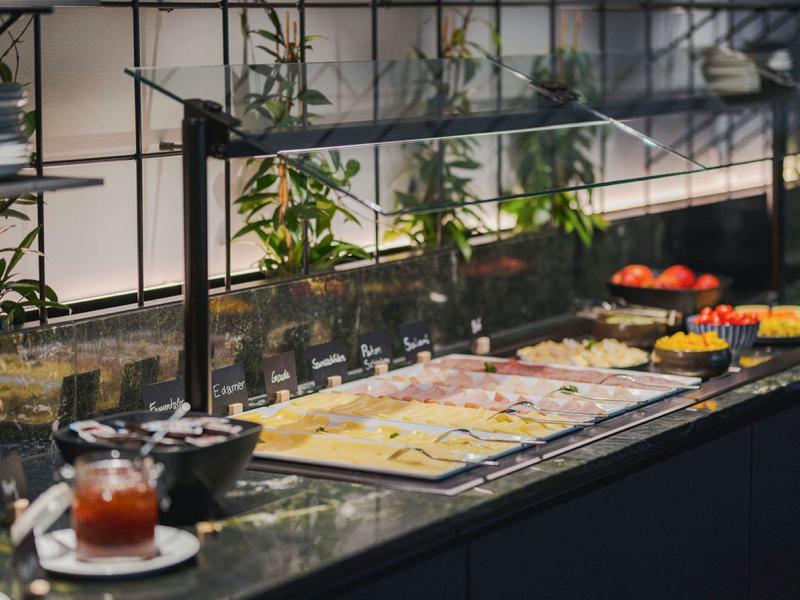 Bufet s výběrem uzenin a sýrů v hotelovém prostředí.