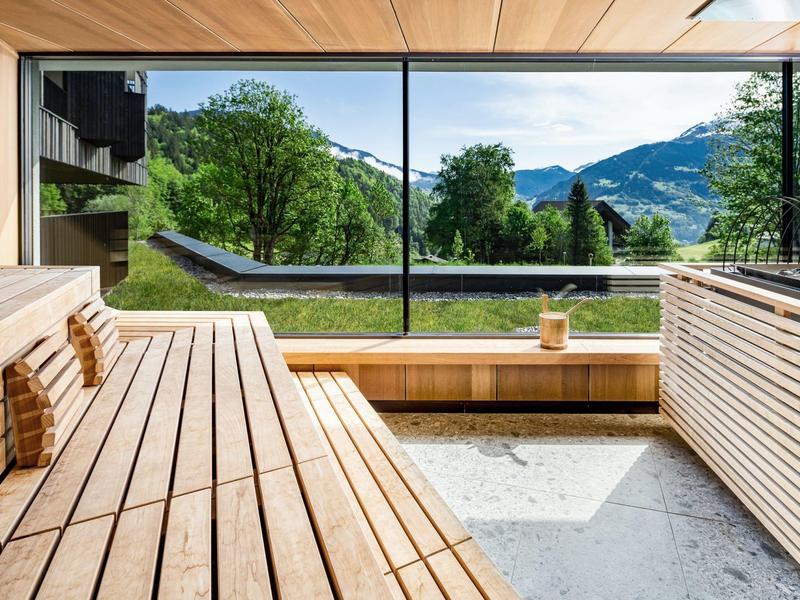 Sala sauna moderna con grande finestra e vista sulle montagne