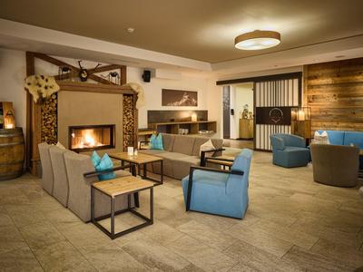 Elegante hotel lounge met open haard, comfortabele stoelen en warme sfeer.