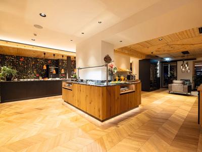 Modern hotel lobby area with wooden flooring and stylish reception desks.