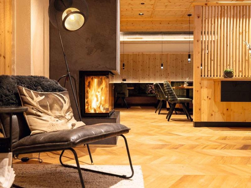 Cozy waiting area with leather chair, fireplace, and warm wooden interior
