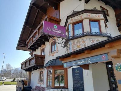 Hotel alpino tradizionale con facciata decorativa e balconi, insegna con il nome Schwärger.