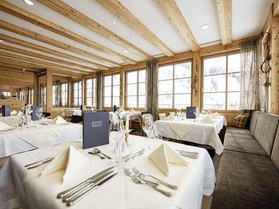 Elegantes Restaurant mit holzverkleideten Wänden, großen Fenstern und ruhig gedeckten Tischen.