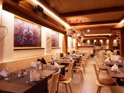 Restaurant confortable avec mobilier en bois, cœurs décoratifs et éclairage chaleureux.