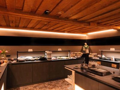 Buffetbereich mit Holzdecke, warmem Licht und verschiedenen Speisen auf Theken.