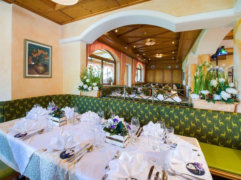 Elegantní restaurace s slavnostně prostřenými stoly a dřevěným interiérem.