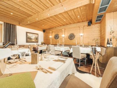 Ristorante luminoso e accogliente con pareti in legno e tavoli apparecchiati in un hotel.
