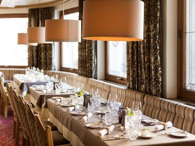 Ristorante elegante con un lungo tavolo, tovaglie bianche e posti elegantemente apparecchiati.