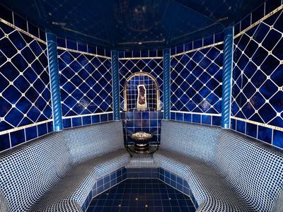 Sala vapore lussuosa con pareti piastrellate blu e fontana centrale