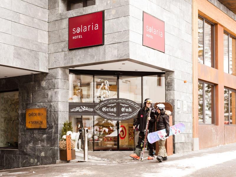 Ingresso di un hotel con due persone in piedi all'angolo della strada.