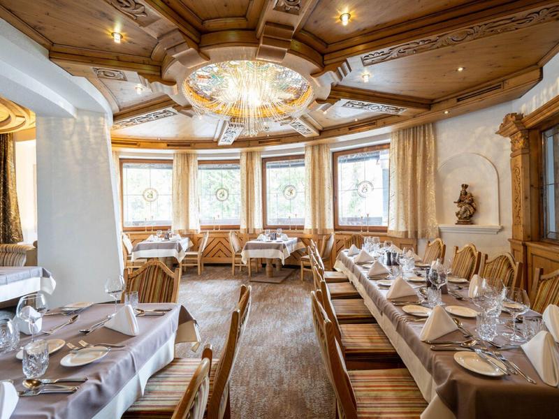 Sala da pranzo elegante con mobili in legno, grandi finestre e illuminazione di stile.