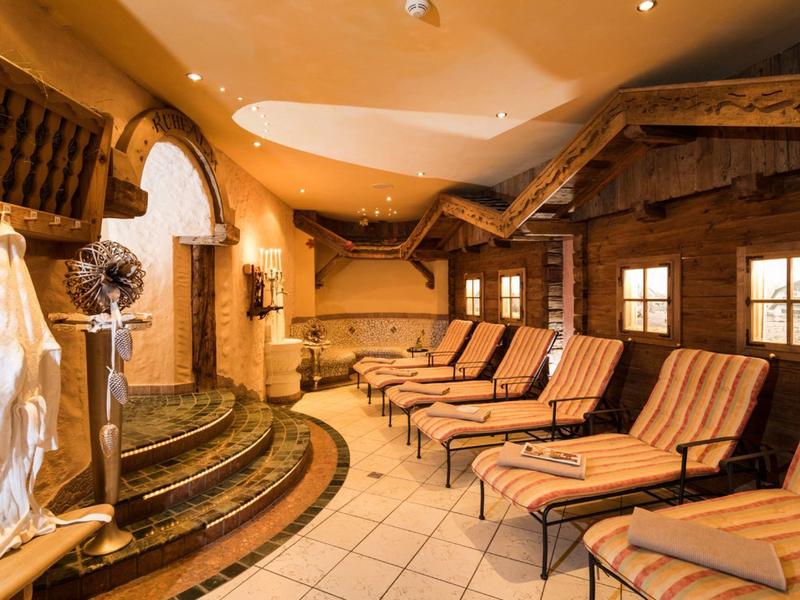 Sala relax con più lettini e design in legno caldo in un'area benessere.