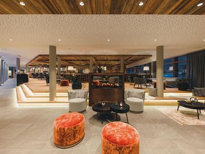 Moderner Hotel-Lobbybereich mit bequemen Sesseln, Teppichen und stilvoller Beleuchtung.