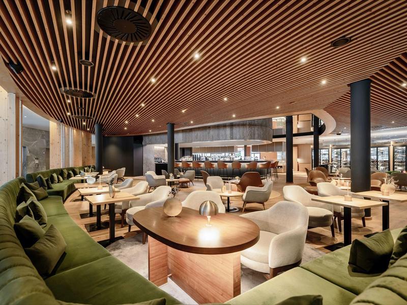 Ristorante moderno con tavoli in legno eleganti, sedie confortevoli e accenti caldi in legno.