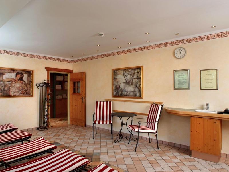 Coin détente confortable avec deux fauteuils rayés rouge et blanc et des peintures décoratives au mur.