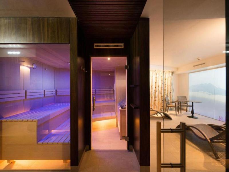 Modern spa area with sauna, cozy lighting, and panoramic view of the landscape.