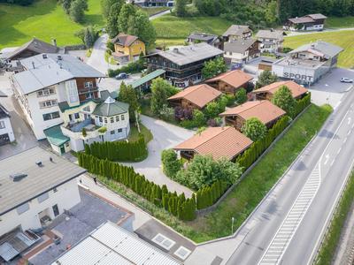 Complesso alberghiero con più edifici circondati da un giardino recintato accanto a una strada.