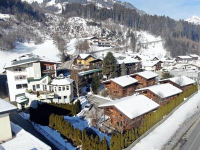 Villaggio di montagna innevato con case di legno tradizionali e edifici moderni.