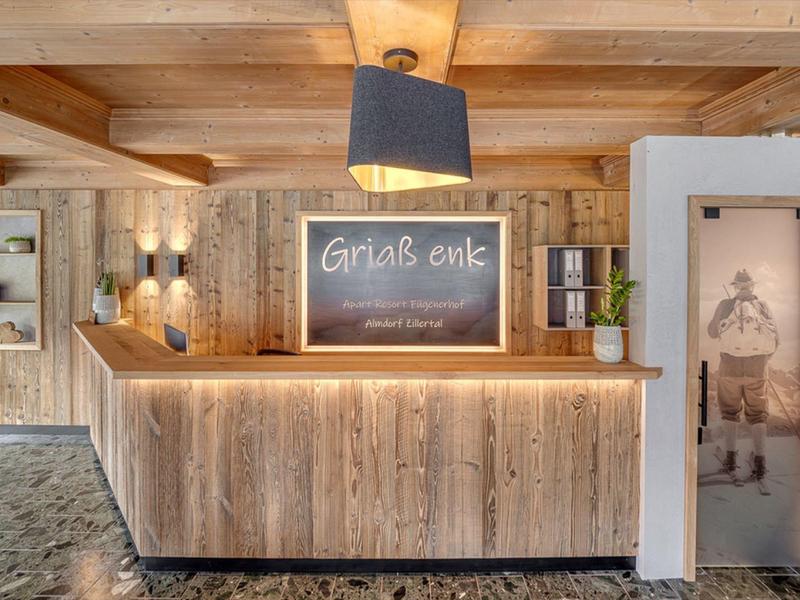 Accoglienza rustica dell'hotel con pannelli di legno e luce calda.