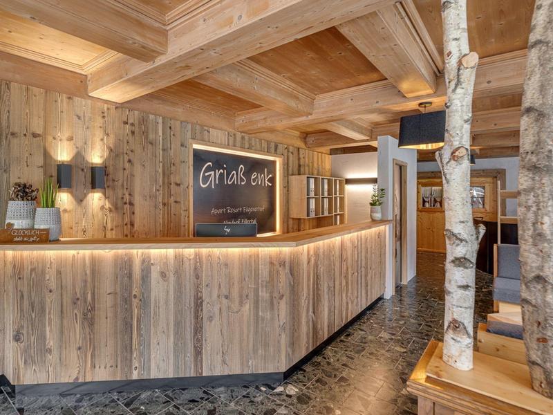 Reception d'hotel rustica in legno con decorazioni naturali e illuminazione calda.