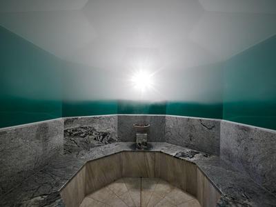 Baño de vapor con paredes neblinosas y área de asiento de baldosas de mármol.