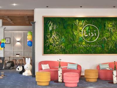 Área de descanso acogedora en hotel con sillones coloridos, pufs y decoración con globos y peluches grandes.