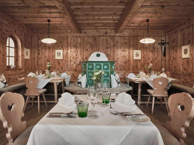 Restaurante acogedor con paredes de madera, muebles rústicos y horno decorativo en el centro.