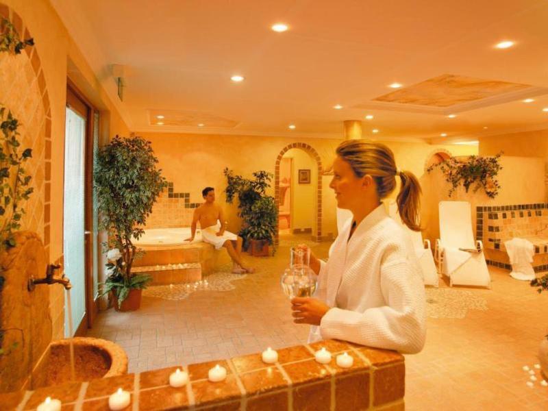 Relaksujący pokój spa z światłem świec, roślinami i przytulną atmosferą.