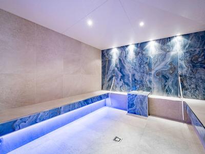 Moderne spa met blauwe marmeren muren en indirecte LED-verlichting