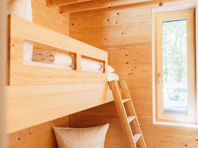 Bright room with wooden bunk bed and window overlooking outdoors