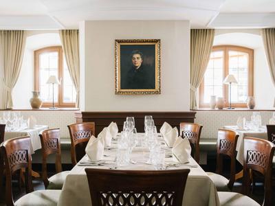 Ristorante elegante con tavolo apparecchiato e ritratto sopra il camino.