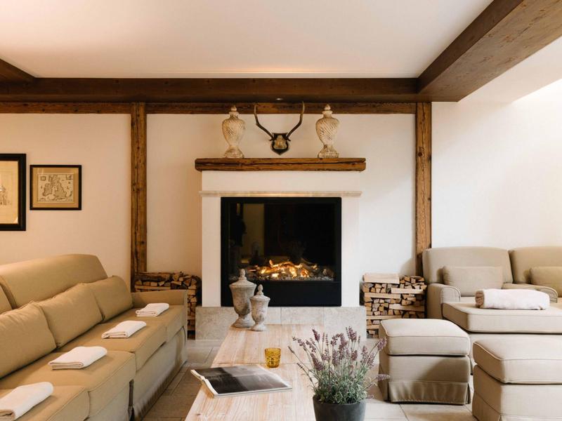 Accogliente zona salotto con divano, camino ed elementi in legno rustici in un soggiorno.