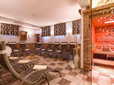 Ontspanningsruimte met ligstoelen en sauna in warm licht met natuurlijke houtdecoratie