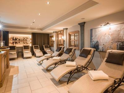 Sala relax con più lettini e illuminazione soffusa in un hotel.