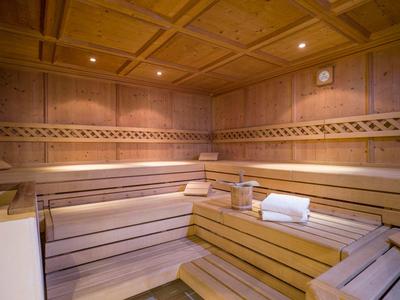 Sauna in legno accogliente con panchine a più livelli e illuminazione soffusa.
