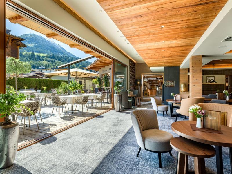 Area interna ed esterna moderna di un hotel con comodi posti a sedere e vista montagna.