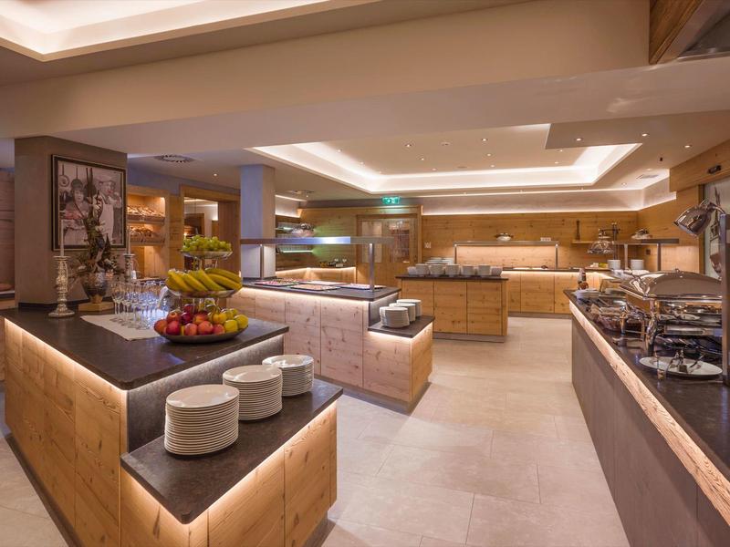 Salotto moderno dell'hotel con divani, illuminazione elegante e area buffet.