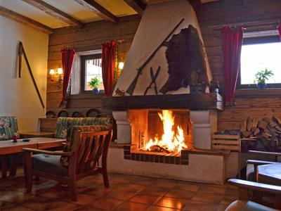 Soggiorno accogliente con camino a legna, divani e mobili in legno con luce calda.