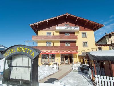 Hotel Beretta in verschneiter Berglandschaft bei klarem Himmel