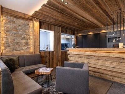 Gemütlicher Hotel-Loungebereich mit Holzakzenten, Steingewand und moderner Einrichtung.