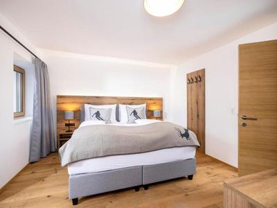 Modern eingerichtetes Hotelzimmer mit Doppelbett, Holzfußboden und hellen Wänden.