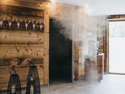 Holzinterieur mit Weinregal, dekorativen Laternen und Dampf im Eingangsbereich eines Hotels.
