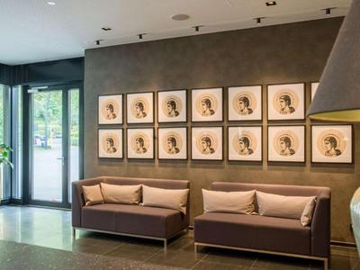 Modern hotel lobby with two brown sofas and artwork on the wall.