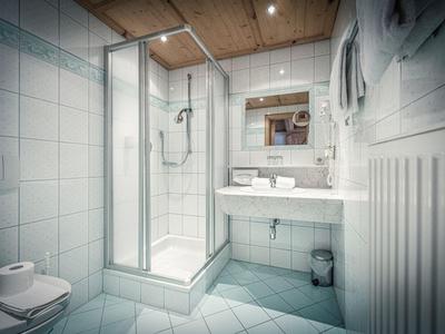 Salle de bain moderne avec douche, toilettes, lavabo et carrelage clair.