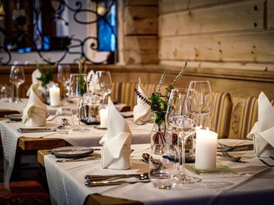 Table à manger élégante dans un hôtel en bois avec serviettes blanches et bougies.