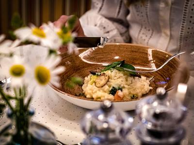 Une table dressée avec une assiette de pâtes et une décoration floue de vase à fleurs.