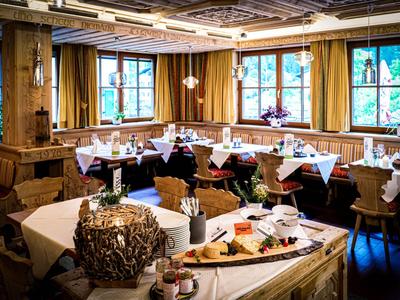 Restaurant chaleureux avec mobilier en bois et grandes fenêtres dans un hôtel.
