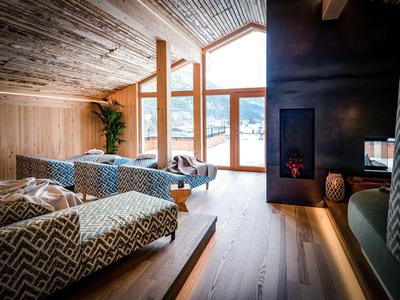 Chambre d'hôtel moderne avec fauteuils confortables et grande fenêtre offrant une vue.