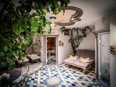 Cour intime avec carrelage bleu, plantes et sièges dans un hôtel.
